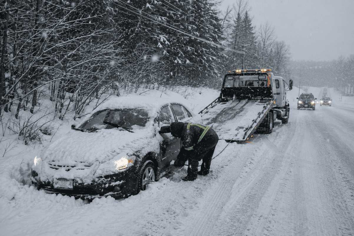 car stuck in snow roadside winter tow truck